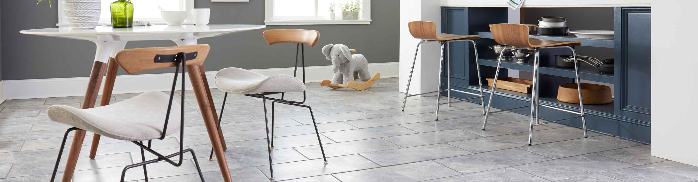 kitchen with stone tile flooring, white kitchen table, and blue counter with barstoolsd blue 